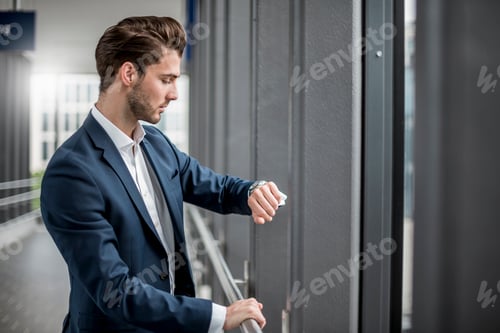 Preview: Businessman in a passageway checking the time