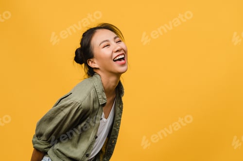 Preview: Portrait of young Asia lady with positive expression, smile broadly on yellow background.
