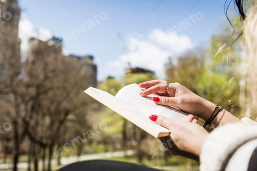 Preview: Cropped image of woman reading book at Central Park
