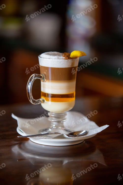 Preview: Vertical shot of a tasty glass of barraquito with liquor and milk