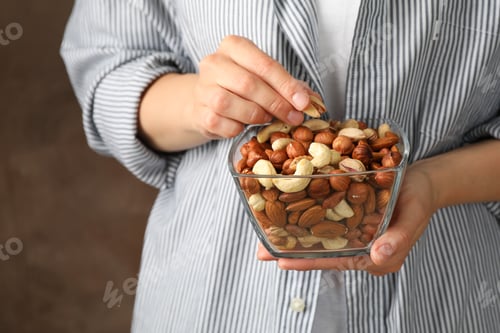 Preview: Woman hold bowl with different nuts. Healthy eating