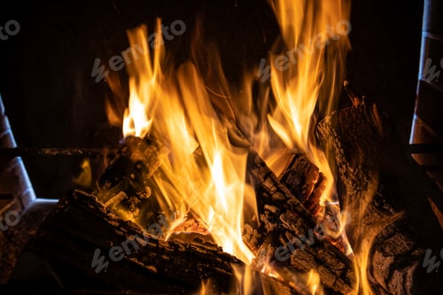 Preview: Fire orange tongues on black background in a brick fireplace