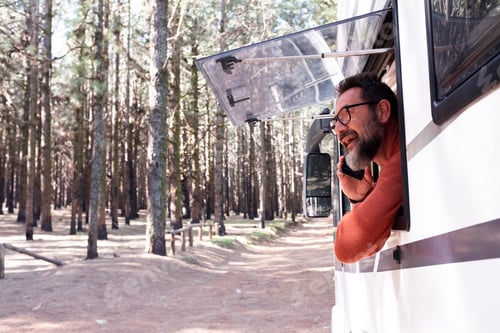 Preview: One man enjoying the view outside the window of a motorhome camper van enjoying vanlife