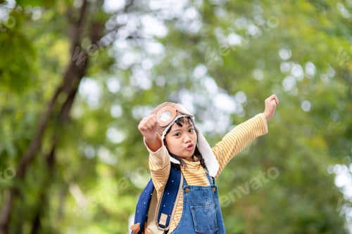 Preview: A cute little girl dressed in a cap and glasses of a pilot. The child dreams of becoming a pilot.