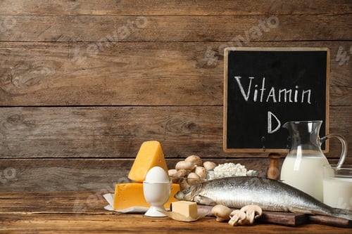 Preview: Chalkboard with phrase VITAMIN D and fresh products on wooden table