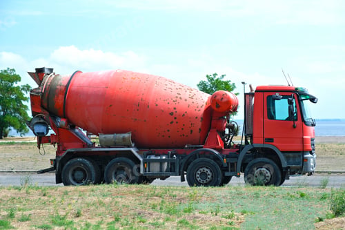 Preview: Large red old rusty concrete mixer stands on the street. Clear sunny day. Repair, industry.