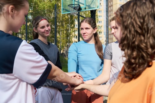 Preview: Group of Teenager Girls Forming Team Huddle before Playing Streetball