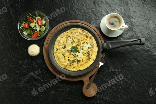 Preview: Tasty brunch. Delicious omelette, salad and coffee served on black textured table, flat lay