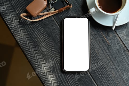 Preview: Top view of smart phone with white empty screen and cup of coffee on rustic wooden table.