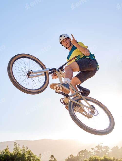 Preview: Bike, jump and rock on hand sign with a man bmx rider jumping over a ramp on a trail or course in n