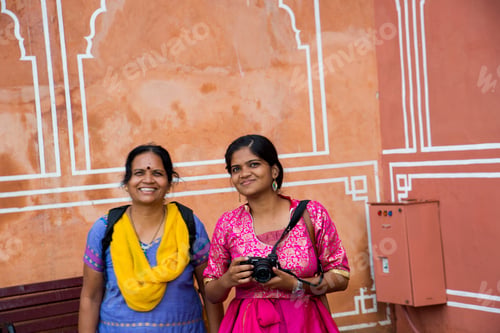 Preview: Indian women in traditional clothes on red wall background