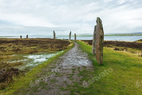 Preview: Wide shot of Ring of Brodgar in Orkney Island in Scotland with a cloudy gray sky in the background
