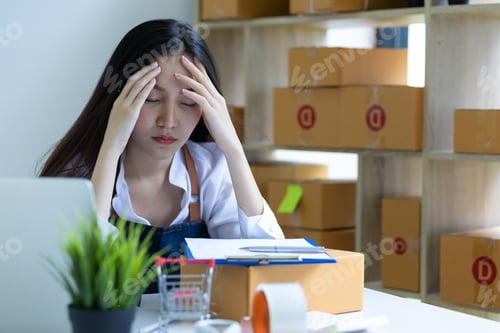 Preview: A young woman starting an online business works on her laptop and waits for orders.