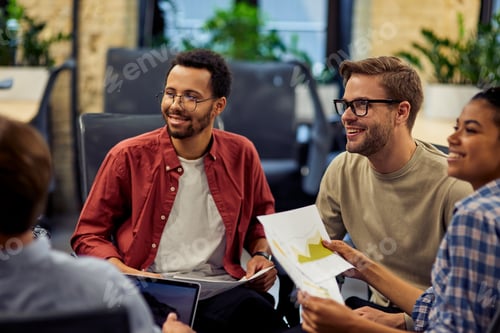 Preview: Group of young and happy diverse multi ethnic business people analyzing project results while