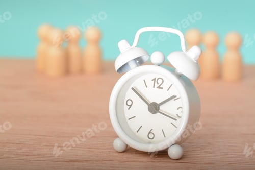 Preview: An alarm clock next to group of wooden people signifies the awakening of teamwork and collaboratio