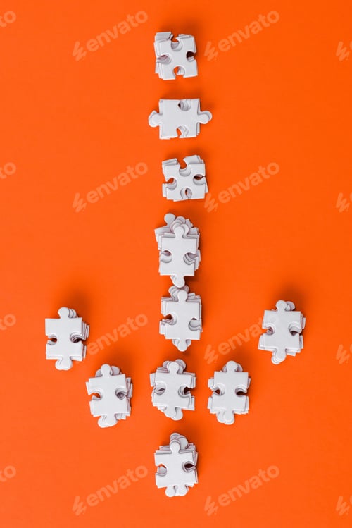 Preview: top view of white direction arrow with puzzle pieces on orange