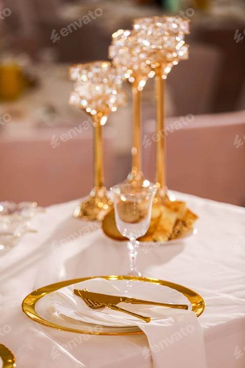 Preview: table decoration with pink tablecloth, crystal candlesticks with candles and white pink flowers in