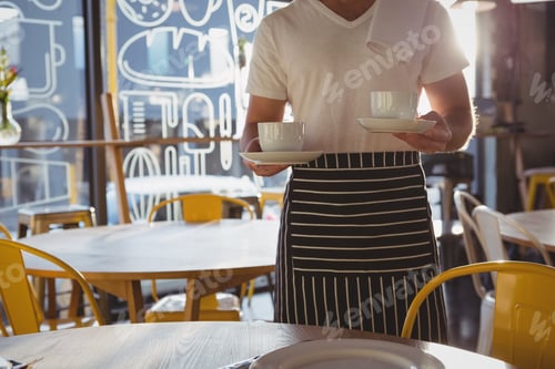 Preview: Mid section of waiter holding coffee cups