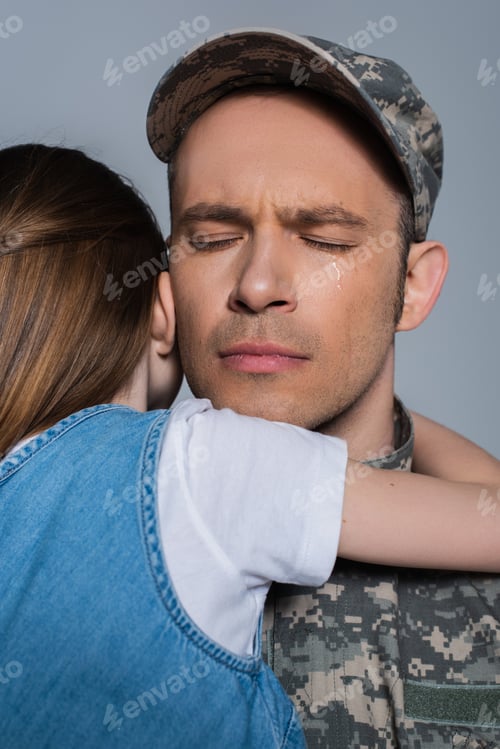 Preview: sentimental serviceman in military uniform crying and hugging with daughter during memorial day