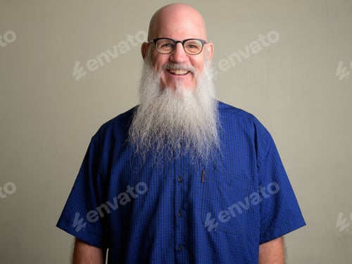 Preview: Happy mature bearded bald man smiling and wearing eyeglasses