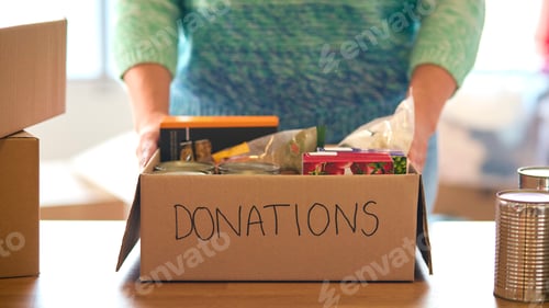 Vista previa: Close Up Of Female Charity Volunteer Working At Food Bank Unpacking Donations