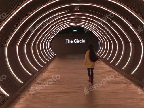 Preview: Young girl passing under passage of neon lights