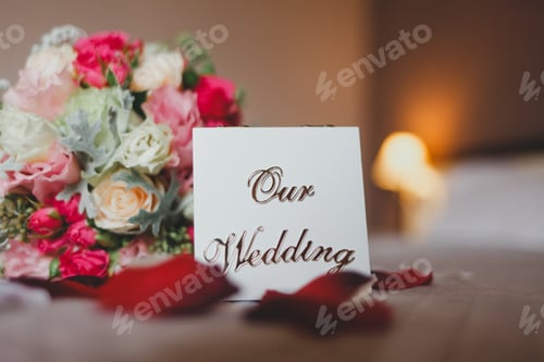 Preview: Box with the inscription our wedding lies on the bed with a bouquet of brides