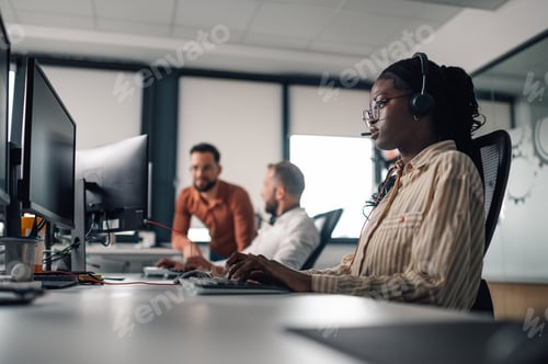 Preview: Customer service representative working on computer in busy office