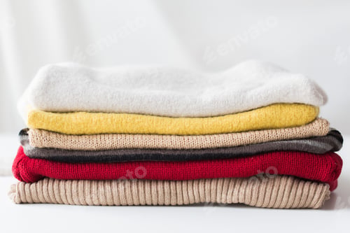 Preview: close up of stacked knitted clothes
