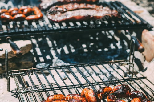Preview: Lamb chops roasting in a barbecue with chourizo
