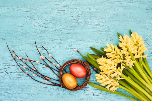 Preview: Easter eggs and yellow spring flowers on blue background. Easter background. Copy space, top view