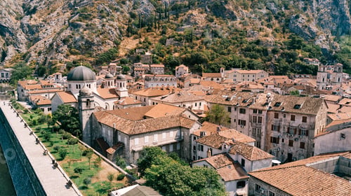 Preview: Church of St. Nicholas among ancient stone houses with red roofs. Kotor, Montenegro. Drone