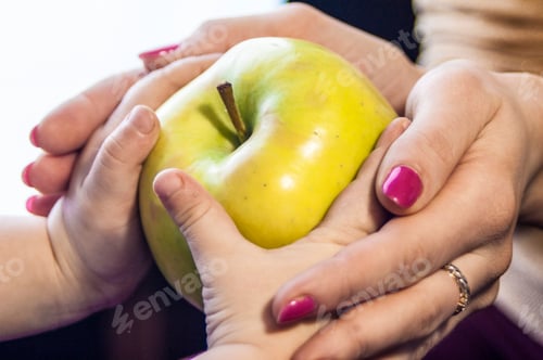 Vista previa: mamá le da al niño una manzana en sus manos