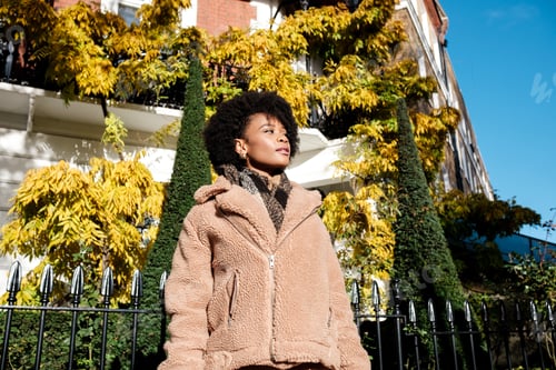 Preview: Relaxed black young woman posing in front of Victorian building.