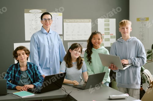 Preview: Group of Diverse Teenagers Collaborating on Laptops in Classroom Setting