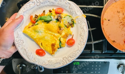 Preview: Delicious Omelet on a Plate over Stove Top