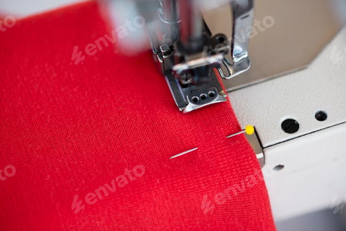 Preview: Close up of sewing machine and red textile in dressmakers workshop