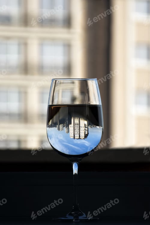 Preview: On windowsill is clear glass of water. Building is reflected in glass of pure natural water.