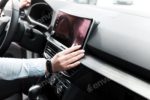 Preview: Woman twists the controls on the car radio. Listening to the radio in the car