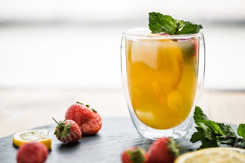 Preview: close-up view of glass with juicy summer cocktail with mint and strawberries