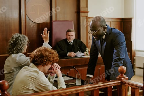 Preview: Middle Aged Black Man Consulting Caucasian Clients during Court Trial