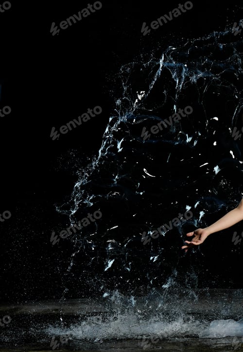 Preview: Woman's hand and a splash of clear water with drops on a black background