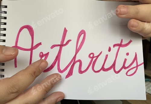 Preview: High angle shot of male hands and a sheet of paper with "Arthritis" text