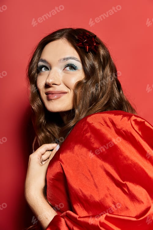 Preview: A young womans joyful expression against a vibrant red background in soft lighting