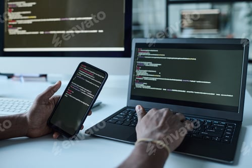 Preview: Developer connecting smartphone with codes to laptop