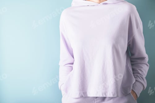 Preview: Cropped view of young adult woman wearing or dressed in stylish lilac sweatshirt and putting her ha