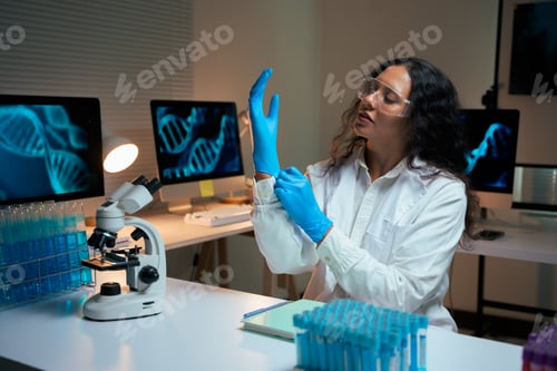 Preview: Scientist putting on blue gloves for laboratory research
