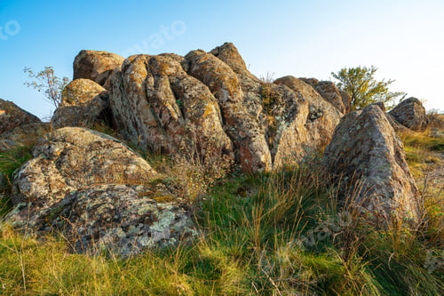 Preview: A small pile of stones in a green-yellow field against the background of a sky in Ukraine