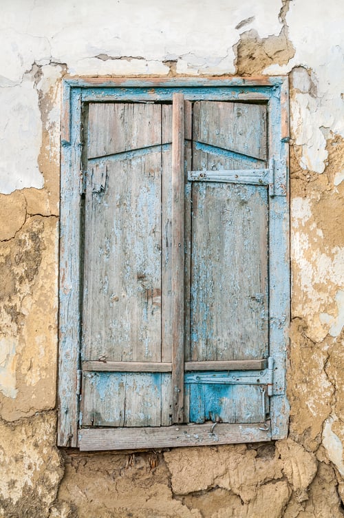 Preview: Old wooden window shutters on the background of the destroyed wa