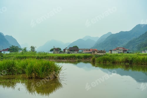 Preview: Rustic village with rice fields, mountain and pond reflection in countryside